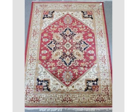 A Heriz carpet, with a central medallion, on a red ground, 280 x 200cm 