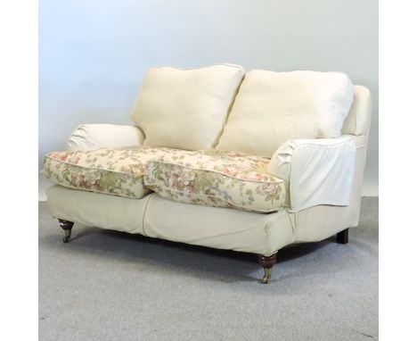 A modern cream and floral upholstered two seater sofa, on turned legs, 143cm