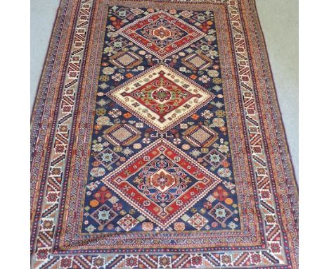 A Shirvan woollen carpet, with three central medallions, and geometric designs, on a blue ground, 297 x 208cm