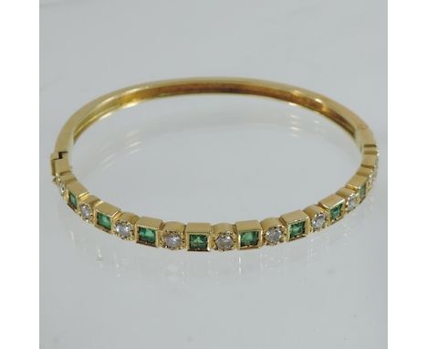 An 18 carat gold emerald and diamond hinged bangle 