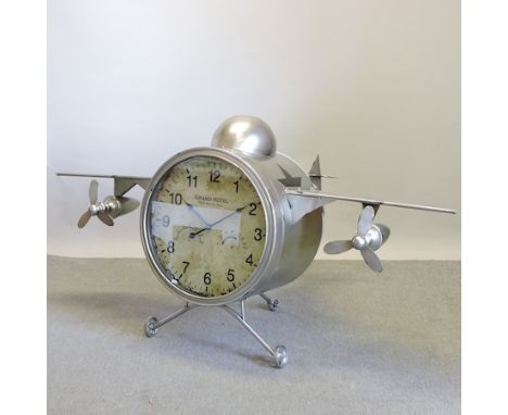 A large metal clock, in the form of a vintage aeroplane, 120cm long