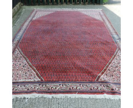 A woollen carpet, with all over medallions, on a red ground, 320 x 210cm 