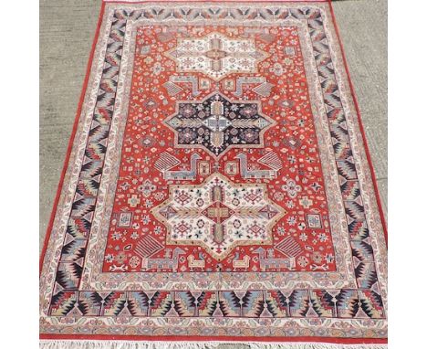 A Persian carpet, with three central medallions, on a red ground, 375 x 270cm
