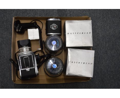 A Hasselblad 500c camera with two spare lenses, spare film back and a shutter release handle.