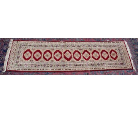 A Persian design runner, cream and red ground with a single row of ten gulls 9'0" x 2'7".