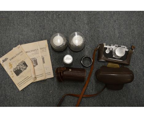 A Leica 35mm camera with leather case and accessories to include lenses, instruction books etc.