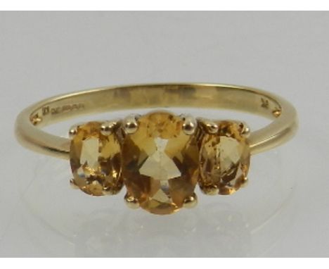 A 9 carat yellow gold and citrine three stone ring. 