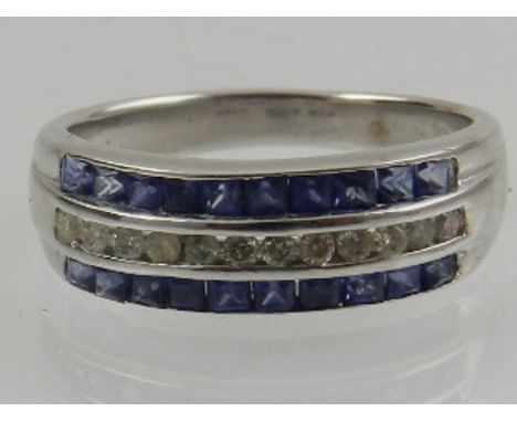 An 18 carat white gold, diamond, and sapphire channel set band ring.