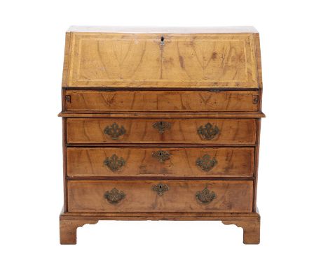 A George II Walnut and Featherbanded Bureau, 2nd quarter 18th century, the fall enclosing a fitted interior of pigeon holes a
