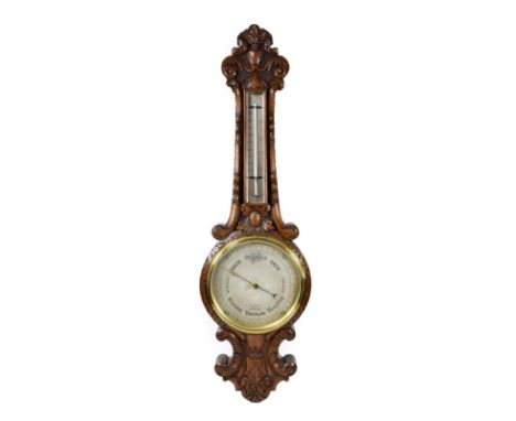 &lt;&gt; A Carved Oak Aneroid Barometer, retailed by E.Lennie, Optician, Edinburgh, circa 1910, case with carved scroll and l