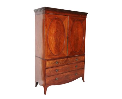 A Late George III Mahogany Linen Press, early 19th century, the moulded cornice above moulded oval panel doors enclosing hang