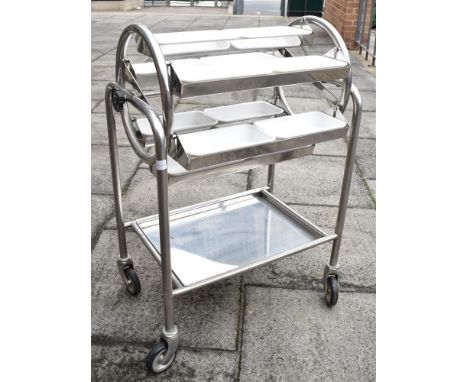 A STAINLESS STEEL FRAMED TEA TROLLEY  with revolving carousel of six hanging compartments each with two removable plastic con
