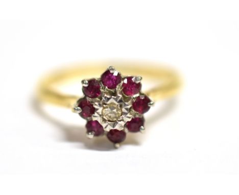 A DIAMOND AND RUBY FLOWER HEAD RING The flower head measuring approx. 8mm in diameter on a yellow metal shank with faded hall