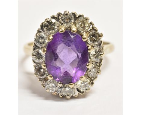 AN 18CT GOLD AMETHYST AND DIAMOND CLUSTER RING  the oval facetted amethyst measuring approx. 0.9cm by 0.6cm and surrounded by