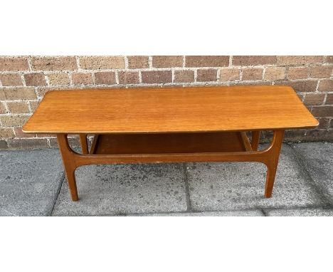 A TEAK COFFEE TABLE  of shaped rectangular form, with magazine rack undertier, 41cm x 116cm, 40cm high Condition Report : lig