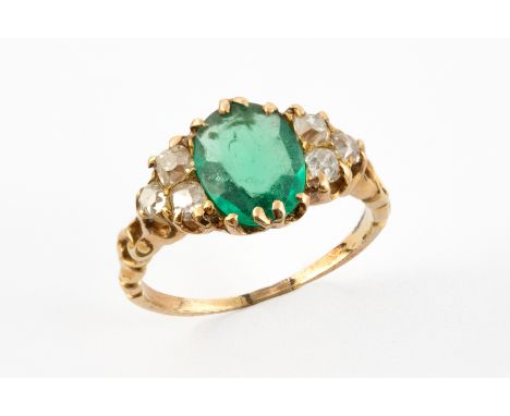 AN EMERALD AND OLD CUT DIAMOND RING The faceted oval Emerald measuring approx. 8mm by 6 mm and flanked each side with three o