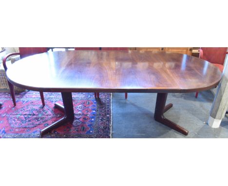 A 1970S EXTENDING CIRCULAR DINING TABLE WITH TWO ADDITIONAL LEAVES on cruciform base, apparently unmarked but probably Danish