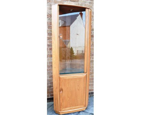 A LIGHT ERCOL CORNER DISPLAY CABINET  the upper glazed section fitted with three adjustable shelves, 72cm wide, 195cm high Co