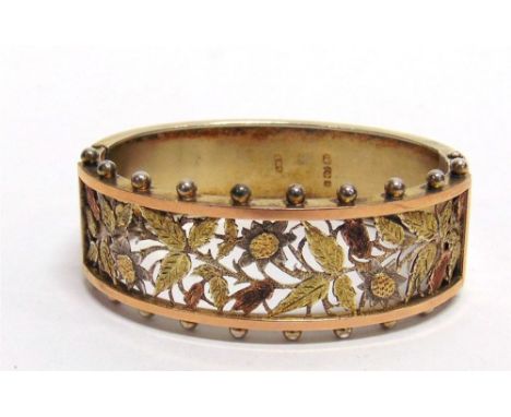 A VICTORIAN SILVER HINGED BANGLE  possibly by John Millward Banks, Birmingham 1883, the frontispiece pierced with three colou