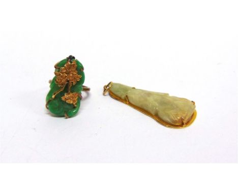 A CARVED JADE PENDANT  of buddahistic figure, 4.8cm long; and a carved jade ring with an overlay of leaves, in 9 carat gold, 