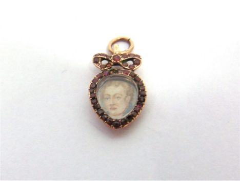 A GARNET PORTRAIT PENDANT  with a bow surmount, with miniature portrait of a gentleman, locket back, 2.2cm long