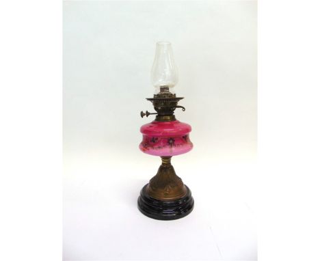 A VICTORIAN OIL LAMP  With painted pink glass reservoir, height 50cm
