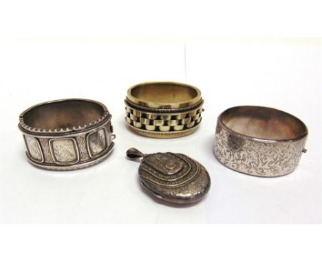 A VICTORIAN HINGED BANGLE, CIRCA 1880 with Aesthetic movement panels to the frontispiece; another hinged bangle and a locket 
