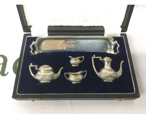 A cased silver miniature tea and coffee service and a cased silver plated set (2). Shipping category B.