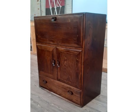 An Ercol 'Windsor' dark elm cabinet/bureau, model 469, height 102cm, width 82.5cm and depth 45cm, together with two Ercol cha