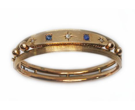 A late Victorian/Edwardian diamond and sapphire bangle, sponsor 'NBs', marked '9ct', wt. 18.5g.  Condition - metal set with s