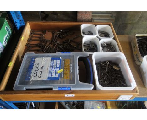 A wooden tray containing various vintage keys and door locks etc