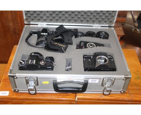 A case containing Minolta X300 camera, a Chinon CE-5 camera, Zenith EM camera