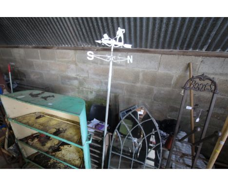 A white painted weather vane mounted to stake decorated with a gardener at work