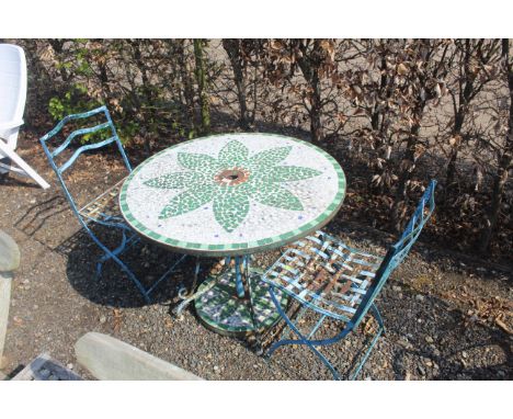 A mosaic patterned tile topped circular garden table, similar patterned parasol base and pair of folding metal chairs