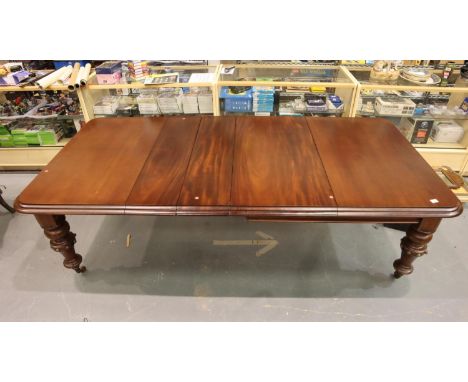 A Victorian mahogany wind out extending dining table with three additional leaves, raised on substantial turned supports, re-