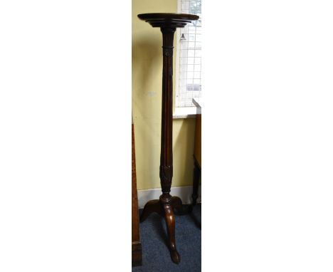 An antique carved mahogany tripod bedpost tochere, 139cm high. 
