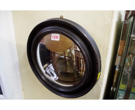 An ebonized framed circular convex mirror, 33cm diameter.  Condition Report: Mirror plate not too bad. A slight deterioration