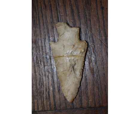 A Neolithic arrow head, 8cm long, (re-stuck).