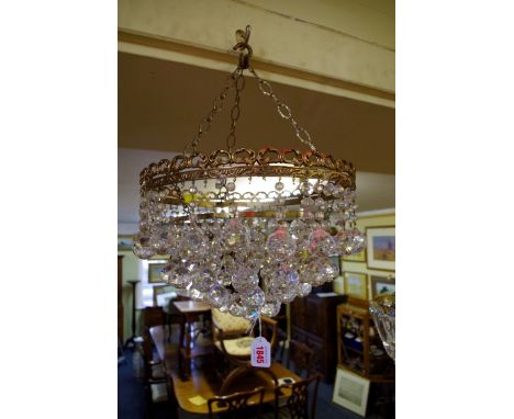 A brass and faceted glass drop four tier ceiling light, 31.5cm diameter. 