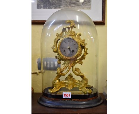 A 19th century gilt metal mantel clock, in the Rococo style, with glass dome, striking on a bell, the clock 29.5cm high. 