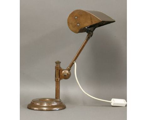 A copper desk lamp,with a rise/fall mount raised on a dished stand,44cm high
