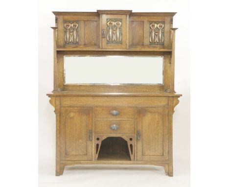 An oak sideboard,the raised back centred with a cupboard, mounted with copper panels over a bevelled mirror plate, the base c