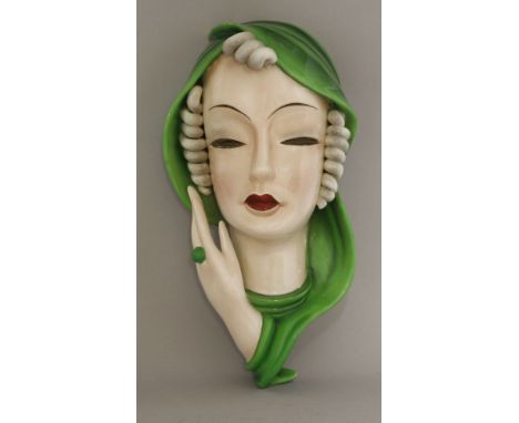 A Goldscheider pottery wall mask,modelled as a lady with curled hair and a green scarf, printed mark, impressed '7813' and in