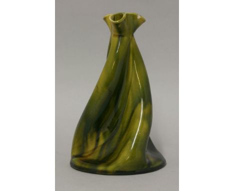 A pottery vase,possibly Linthorpe after a design by Dr Christopher Dresser, with a spiral twisted conical body with a green/y