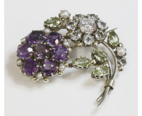 A late Arts and Crafts silver spray brooch,attributed to Dorrie Nossiter, with clusters of gemstones to include amethysts, aq