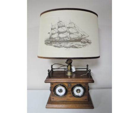 A contemporary mahogany ship's style table lamp with shade depicting a clipper, fitted with a thermometer and barometer