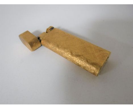 A Cartier gold plated cigarette lighter in a textured bark finish