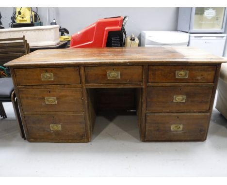 An antique pine twin pedestal desk, fitted seven drawers with brass drop handles