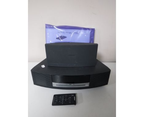 A Bose Wave music system with speaker, leads, instructions and remote