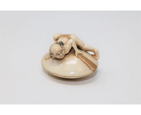 A Japanese ivory netsuke depicting a man on a clam shell, Meiji period, length 4cm